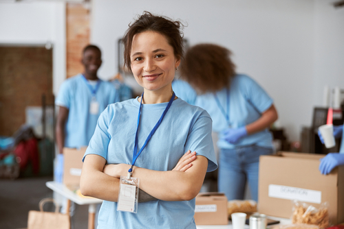 A Blood Bank of Delmarva volunteer at a blood drive standing with her arms crossed in a blue shirt.