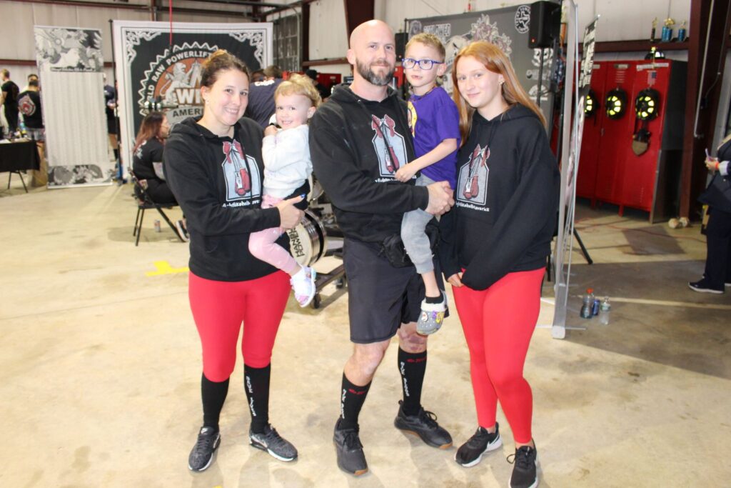 Jason Painter with holding his son Maverick and posing with his family.